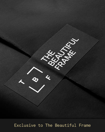 The Beautiful Frame branded presentation sleeve on premium black tissue paper, showcasing the distinctive TBF identity and reinforcing the premium unboxing experience exclusive to The Beautiful Frame.